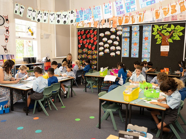 A wide shot of a classroom with students sitting at desks doing their work.